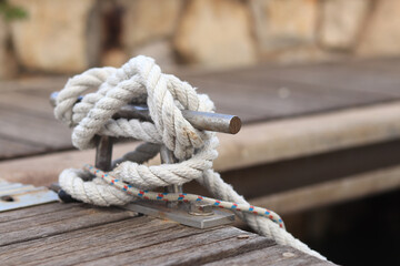 Mooring post, a mooring knot on a yacht pier. The yacht's mooring ropes are attached to the knecht. Knecht on the deck on the pier for fastening ropes. Knecht for mooring and fastening ropes
