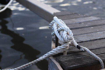 Mooring post, a mooring knot on a yacht pier. The yacht's mooring ropes are attached to the knecht. Knecht on the deck on the pier for fastening ropes. Knecht for mooring and fastening ropes