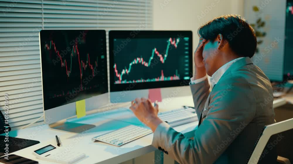 Poster stockbroker is watching stock market charts on his computer screens. he is becoming increasingly fru