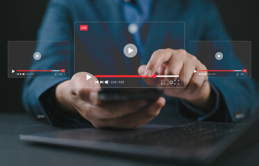 Live streaming and video content creation concept. A man uses a smartphone device with transparent video player interfaces, symbolizing live streaming, digital media, and video content creation.