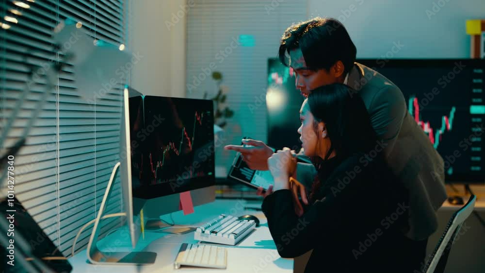 Poster Business team working late, analyzing data on a computer and tablet. Colleagues engage in discussions about strategies and financial trends in a collaborative office environment