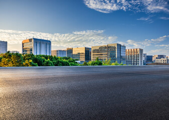 Asphalt road with modern city buildings scenery at sunset. car advertising background.
