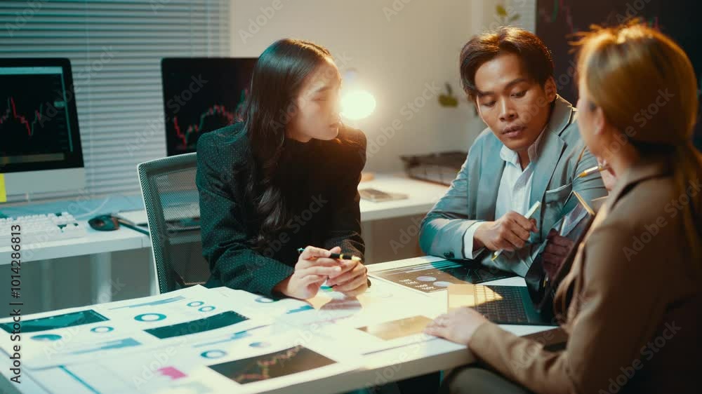 Aufkleber team of financial analysts are reviewing charts and data in their office. the group is having a focu