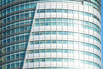 A beautiful background of an glass office building, reflecting clouds in the opened windows