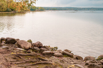 Water's edge at the stone shore of the lake. Autumn sketch.