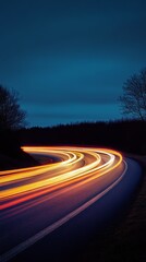 Fototapeta premium Long exposure of car light trails on a winding road at night