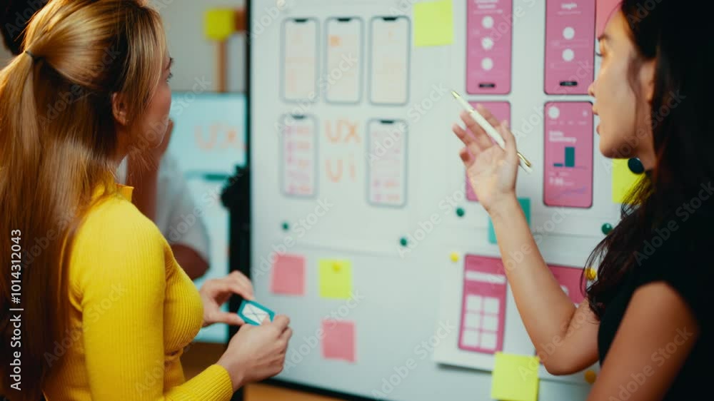 Aufkleber Asian ui/ux designers are working together to develop a mobile application, discussing the user interface and user experience on a whiteboard