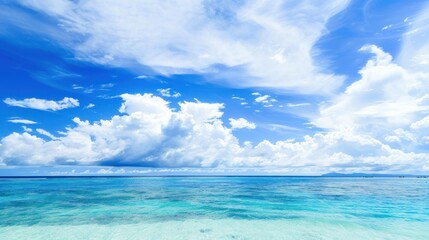 Fototapeta premium Clear blue sky with white clouds over turquoise ocean. Tropical seascape for travel and nature designs.
