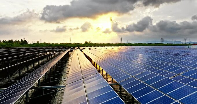 Aerial view of solar power plant landscape at sunset. Solar panel power station on the lake.