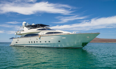 Boat or yacht on Coronado Island visiting LORETO on summer vacation in Baja California Sur Mexico with blue sky and clouds in the background.