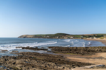 Croyde beach with waves and surfers, Devon. Surfing in England.
