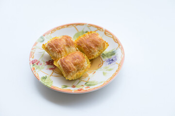Pineapple tart cookies also known as Nastar served in a ceramic plate, isolated on white background.