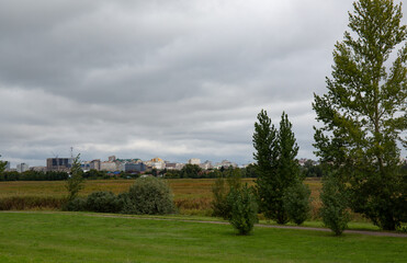View of the city from the field. Cloudy day. Omsk in summer