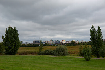 View of the city from the field. Cloudy day. Omsk in summer