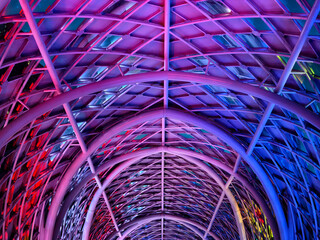 A stunning tunnel with vibrant purple and blue ceiling lights