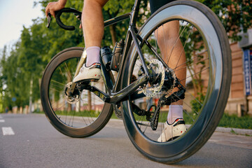Fototapeta premium Unrecognizable sportsman in professional cycling leather shoes riding bike