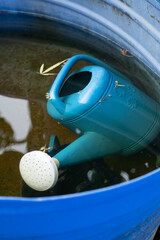 Watering can in blue water tank