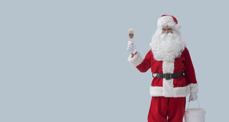 Santa Claus holding a paintbrush and a bucket