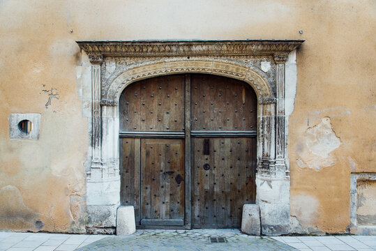 ancienne porte en bois et mur jaune orange. Vieille porte coch&egrave;re et arche d&eacute;cor&eacute;e &agrave; Troyes. Belle porte d'entr&eacute;e s&eacute;curis&eacute;e. Porte &agrave; clous.