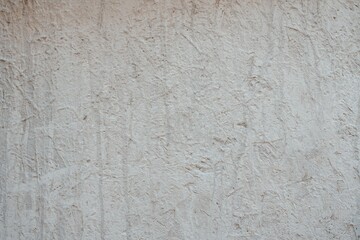 Textured Plaster Wall Background. A close-up of a textured plaster wall with an abstract rough surface. The neutral light beige color and irregular patterns create a natural and artistic backdrop. 