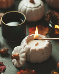 Handmade candles made of coconut and soy wax in a concrete, plaster candlestick with a wooden wick. Scented candle in a pumpkin-shaped candlestick. Selective focus