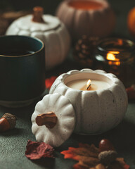 Handmade candles made of coconut and soy wax in a concrete, plaster candlestick with a wooden wick. Scented candle in a pumpkin-shaped candlestick. Selective focus