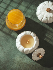 Handmade candles made of coconut and soy wax in a concrete, plaster candlestick with a wooden wick. Scented candle in a pumpkin-shaped candlestick. Selective focus