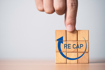 Hand assemble wooden block cube with recap and backward icon.