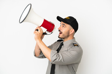 Young security  caucasian man isolated on white background shouting through a megaphone