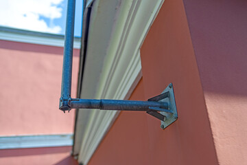 vertical metal pole securely attached to a brick wall using robust mounting brackets, showcasing effective integration of structural support and architectural design