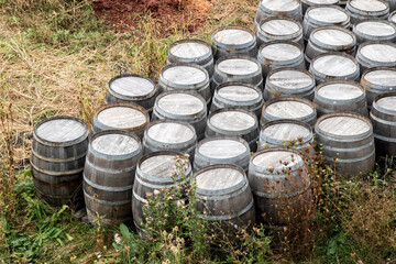 Used wooden wine barrels stacked in row on countryside winery yard