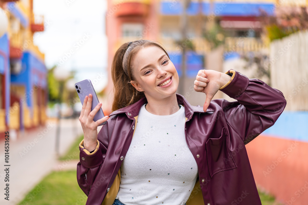 Canvas Prints Young pretty girl using mobile phone at outdoors proud and self-satisfied