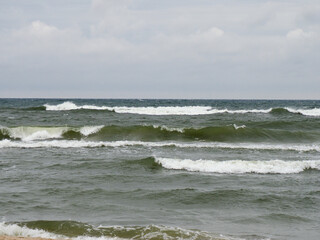 Greenish Waves of the Black Sea Under Cloudy Sky with Beach Background