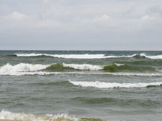 Greenish Waves of the Black Sea Under Cloudy Sky with Beach Background