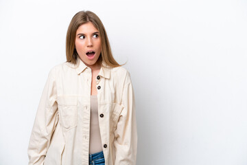 Young caucasian woman isolated on white bakcground doing surprise gesture while looking to the side