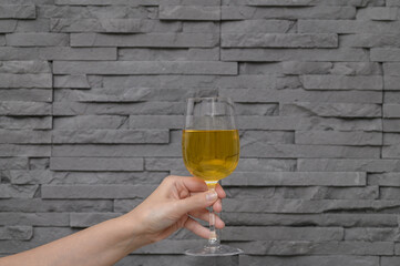 Kieliszek białego wina wzniesiony do góry jak do toastu  © Paweł Kacperek