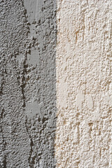Detail of a grey and beige painted exterior wall - background wallpaper