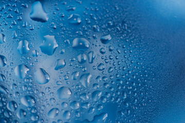 青背景のガラスに着いた水滴