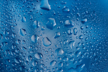 青背景のガラスに着いた水滴