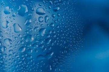 青背景のガラスに着いた水滴
