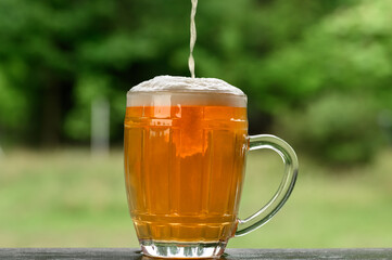 Kufel piwa jasnego z pianką, nalewać piwo