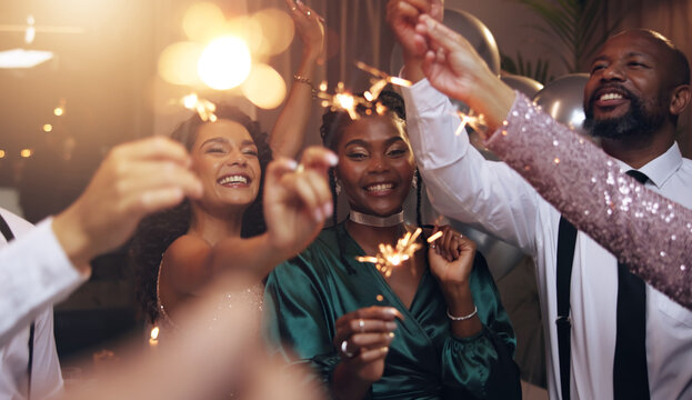 Business people, party and sparklers at night for celebration, diversity and happy for new year countdown. Women, men and smile for friends with fireworks, connection or cheers in group at gala event