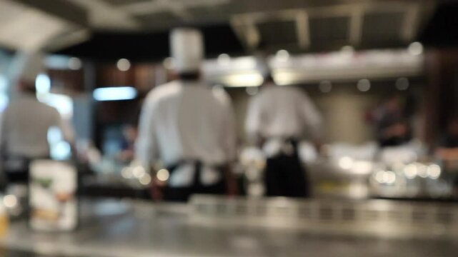 Chef cooking in restaurant kitchen blurred defocused background