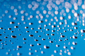 Side view of tiny water droplets on a clear blue background. Rain patterns concept
