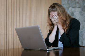 Stressed Woman Covering Face in Front of Laptop: Burnout, Overload, and Workplace Anxiety in the Digital Age