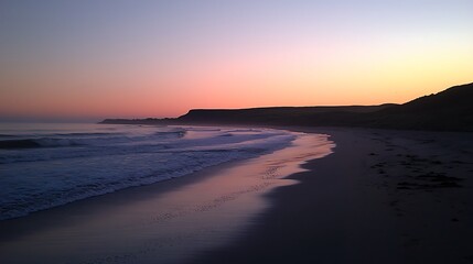 Obraz premium Serene Sunset Over Sandy Beach With Gentle Waves and Silhouetted Coastline