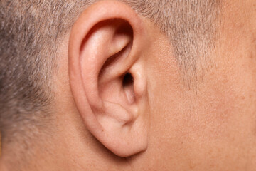 Obraz premium Closeup of a man's ear showing detailed shape and structure of helix and earlobe profile in medical context focused on audiology and hearing health care