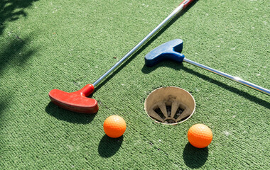 Golf stick and ball on green grass close up.