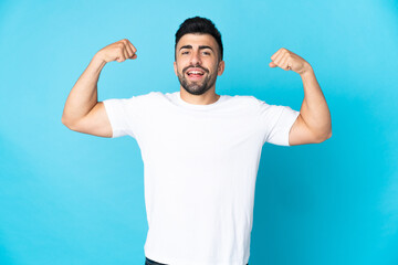 Caucasian man over isolated blue background doing strong gesture