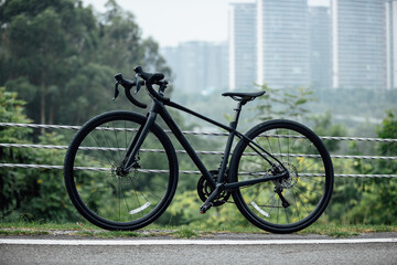 Fototapeta premium A road bike on road side with city in the distance